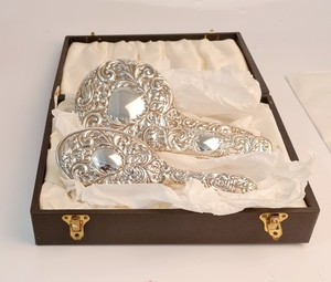 A hallmarked silver dressing table set, comprising of a hand mirror, hair brush and clothes brush