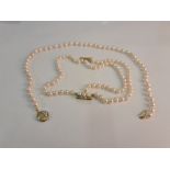 A double row set of cultured pearls with diamond set clasp, assessed as 14ct, along with a single