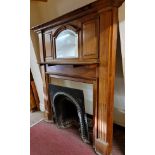 An early 20th Century solid oak, raised back mirrored and panel fire surround, fluted column sides