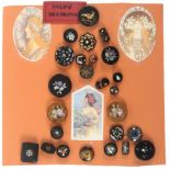 A display of twenty five 19th Century buttons, mostly inlaid including glass, horn, celluloid,