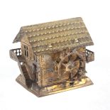 A gilt brass novelty tape measure in the form of a Swiss chalet style water mill, the complete