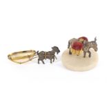 A pin cushion and a pin cart, the first in the form of a white metal mule carrying two gilt pin
