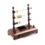 A rosewood reel stand, circa 1840, the canted rectangular base raised on bun feet and
