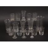 A collection of glass medicine measures, comprising three baluster form lipped examples, largest