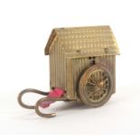 A gilt brass novelty tape measure in the form of a bathing cart, replacement inked tape in ins., and