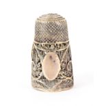 A late 18th Century English silver filigree thimble, decorated with quill work around a vacant