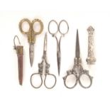 Four pairs of scissors two with sheaths, comprising a pair with cherub head loop mounts with sheath,