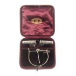 An unusual leather cased set of silver knitting needle protectors and companion wool ball