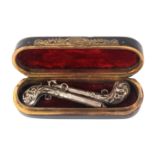 A late 18th Century tortoiseshell and silver inlaid box containing a pair of silver 'charm' pistols,