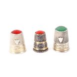 Three continental white metal thimbles, all with stone tops, two with shield cartouches over