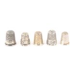 Five attractive English silver thimbles, all hall marked, four with attractive friezes. (5) From the