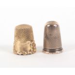 Two gold thimbles, comprising an American example with leaf scroll decorated frieze and vacant