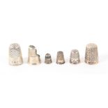 Six English silver thimbles, comprising a finger guard with engraved border, a Charles Homer thimble