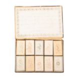 A rare and emotive boxed set of ten cut paper and card needle packet boxes, the outer box lid with a