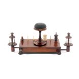 A Regency rosewood 'work stand', the weighted rectangular base raised on four bun feet and fitted