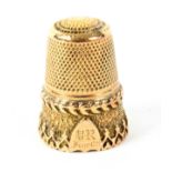 A Victorian gold thimble, the frieze with a feather band over a border of Gothic trefoil arches with