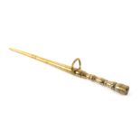 A brass knitting stick, of turned tapering form with brass loop mount, 18cms.