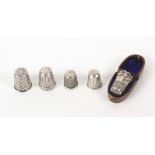 A large collection of thimbles, comprising four damaged silver examples, one in leather case, thirty