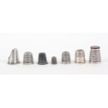 Seven thimbles, comprising a silver example with unusual agate top, two other silver thimbles, a