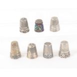 Seven white metal continental thimbles, six with decorative friezes, one in coloured cloisonne