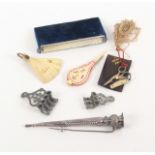 A mixed lot - sewing, comprising two elaborate soft metal needle threaders, largest 4cms, a bone fan