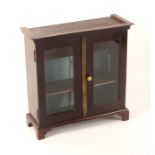 A small late 19th Century mahogany table top display cabinet, enclosed by a pair of glazed doors