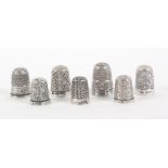 Seven English silver thimbles, all of good gauge and including a large example, mostly with bold