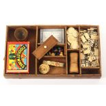 A leather games tray, with two dice shakers, a worn bone totem, and a selection of dominoes,