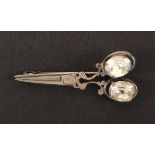 A white metal brooch probably French in the form of a closed pair of scissors, with paste insets