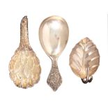 Three caddy spoons, comprising a silver example, the handle commemorating the silver jubilee of