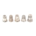 Five unmarked English silver thimbles, comprising three with engraved borders, one early 19th