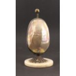 A mother of pearl egg form etui, circa 1870, the circular alabaster base with gilt mount, the egg