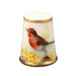 A Royal Worcester porcelain puce mark thimble painted with a bird, resting on foliage and painted