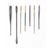 Six bodkins and a tweezer/earspoon, comprising a silver fish form bodkin, 6.8cms, five others, and