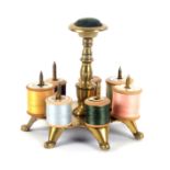 A brass reel stand, the shaped base raised on seven shoe form feet with a turned stem terminating in