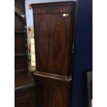 A mahogany standing corner cabinet