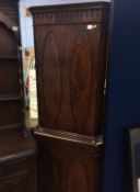 A mahogany standing corner cabinet