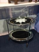 A retro chrome two tier mirrored glass oval tea trolley