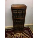 A narrow oak bookcase and a set of Charles Dickens books