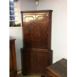 A reproduction mahogany corner cabinet