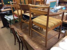 A teak extending dining table and a selection of eight chairs