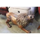 A large carved wooden sculpture of a lion, approx. 104cm length, 60cm height