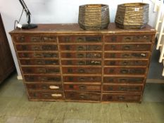 A bank of 24 pine drawers, all with flush brass handles, 133cm width, 87cm height, 35cm depth