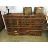 A bank of 24 pine drawers, all with flush brass handles, 133cm width, 87cm height, 35cm depth