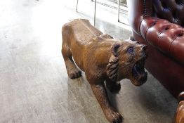 A large carved wooden sculpture of a tiger, approx. 100cm length, 55cm height