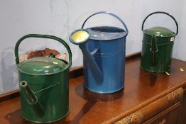 Three metal watering cans