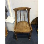 A Gillows of Lancaster rosewood bergère chair, with carved splat and spindled back, supported on