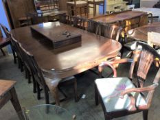 A large mahogany extending dining table, with three leaves and a matched set of ten chairs,