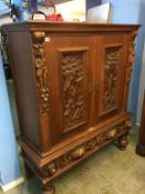 A Continental carved oak two door cabinet and stand, 123cm wide