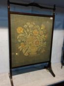 A mahogany framed needlework fire screen